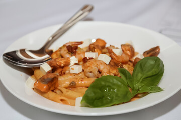 Tasty appetizing classic Italian pasta with a delicious sauce on a white plate.