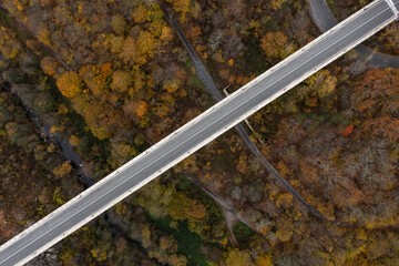 Aerial view of bridge of highway over the river in the mountain at autumn