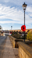 The bridge over the River Tees at Yarm with the knitted red poppy for Remembrance Day .