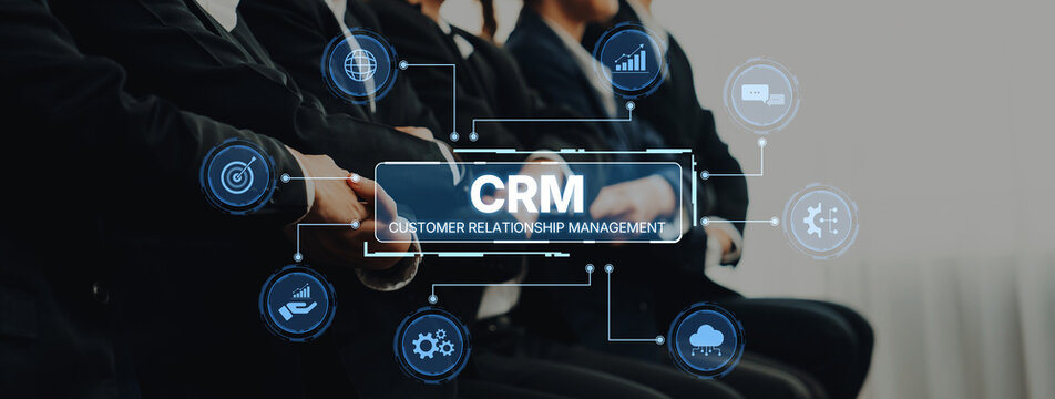 A business team focuses on customer relationship management with a digital interface showcasing CRM concepts in a modern office setting. Collaboration and strategy are key. Trope