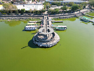 Aerial mid altitude view of pier in Cajititlan Jalisco Mexico captured from the lake over green waters