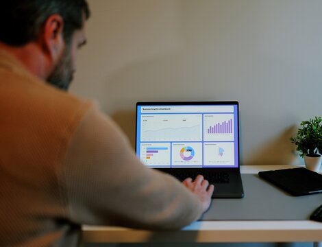 Middle Aged Male Business Analyst Sorting Through Graphs and Charts Preparing for Executive Presentation - Business Analysis Concept