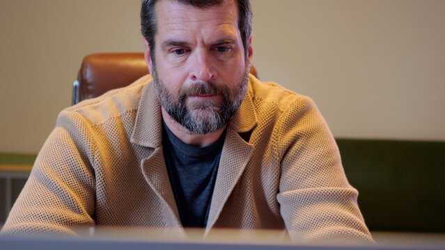 Middle Aged Male Business Analyst Sorting Through Graphs and Charts Preparing for Executive Presentation - Business Analysis Concept