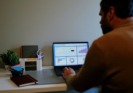 Middle Aged Male Business Analyst Sorting Through Graphs and Charts Preparing for Executive Presentation - Business Analysis Concept