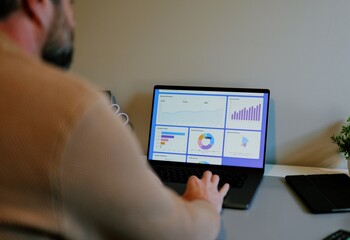 Middle Aged Male Business Analyst Sorting Through Graphs and Charts Preparing for Executive Presentation - Business Analysis Concept