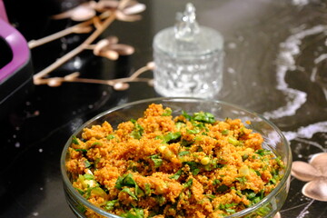 An image of kısır made with homemade bulgur in a glass bowl. Lettuce, green onions, and parsley are added to the kısır. Traditional Turkish food. Vegan diet. Snack plate.