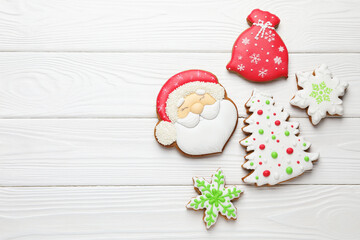 Tasty gingerbread cookies on white wooden table, flat lay. Space for text