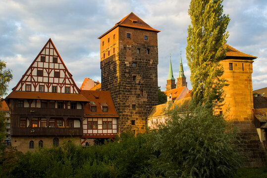 Light slides over old towers and half timbered houses in Nurnberg Germany. Warm stone and wood glow gently in the late sun and hint at a long layered past. Birds drift above quiet rooftops.