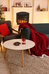 Stylish room with Christmas tree, sofa, fireplace and festive decor. Interior design