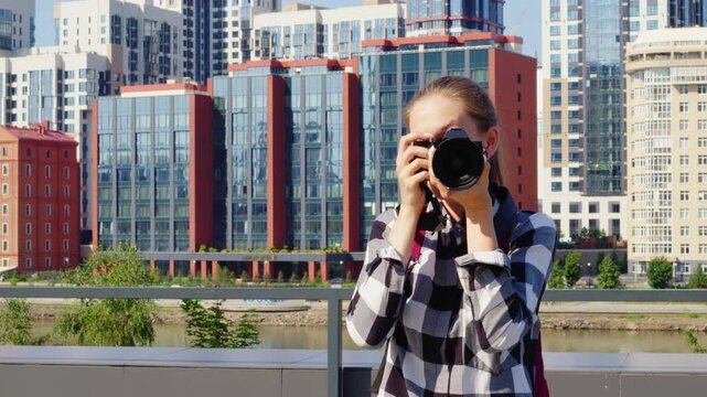 Enthusiastic photographer taking pictures of urban landscape, showcasing creativity and passion for photography against modern architectural backdrop