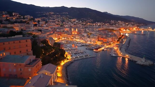 picturesque harbor during twilight hours, historic fortress overlooks tranquil water at evening. Bastia. France