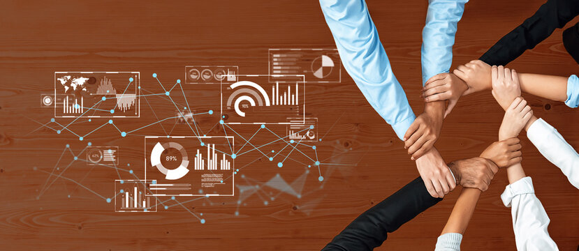 A diverse team engages in collaborative planning around a wooden table, integrating data graphics and charts that emphasize strategic thinking and teamwork. Trope - Powered by Adobe