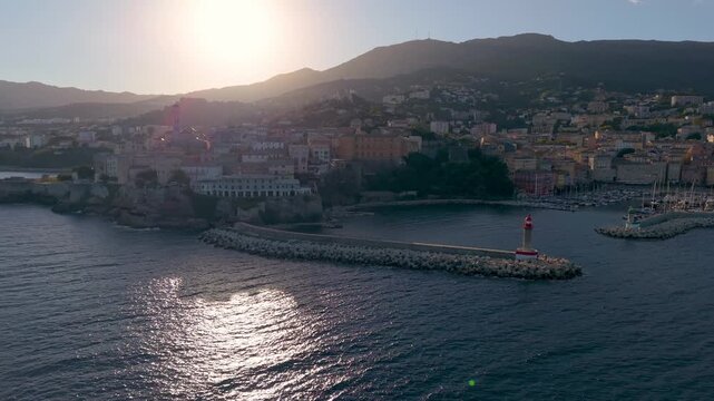 picturesque harbor during twilight hours, historic fortress overlooks tranquil water at evening. Bastia. France