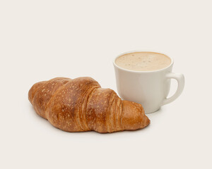 a cup of cappuccino with a croissant on a light background