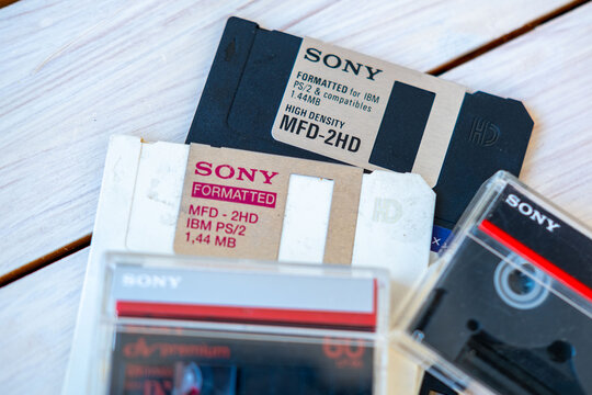 Vintage Microsoft floppy disks for Windows, Sony audio cassette tape, retro computer software installation media, early PC technology, digital nostalgia, information storage, old school technology