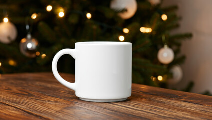 White ceramic mug on rustic wooden table with blurred Christmas tree and warm lights in background. Cozy festive holiday atmosphere, mockup for branding or design.