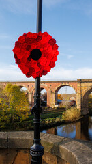 A lamp post on the bridge over the River Tees at Yarm with a large red poppy for Remembrance Day 