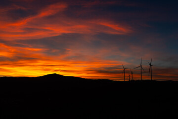 Fototapeta premium Dramatic Sunset Landscape with Wind Turbines Silhouette HDR