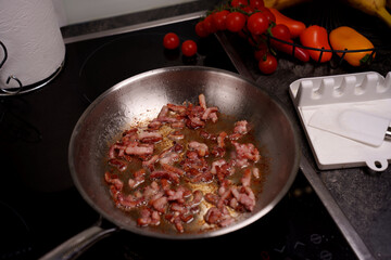 sizzling bacon in metal pan with vibrant tomatoes and peppers ensemble on modern kitchen countertop capturing a cozy culinary moment, gastronomy, culinary, comfort, appetite, crispy, savory