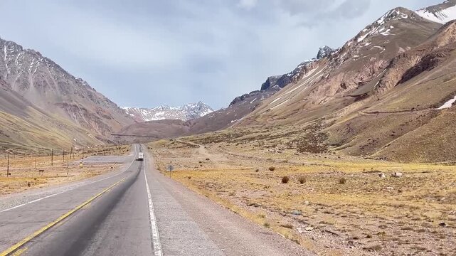 Video footage of straight section of the Paso Los Libertadores road in the Andes Mountains, Chile, near the border with Argentina. The high-altitude highway cuts through rugged mountain scenery.