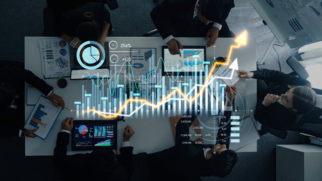 A diverse business team engages in a collaborative work session, analyzing financial data through charts and graphs, fostering insights for strategic decision-making. Scalp