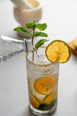 Sparkling soda being poured on Mandarin Lime Mojito cocktail