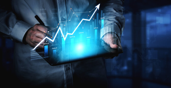 A business professional is analyzing financial data on a digital tablet, showcasing graphs and charts that illustrate growth and market trends in a modern office environment. Scalp