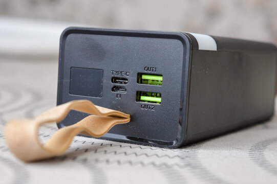 portable power bank with digital display and USB ports held in hand, concept of mobile charging, modern technology, portable energy source, and electronic device for everyday use and travel.