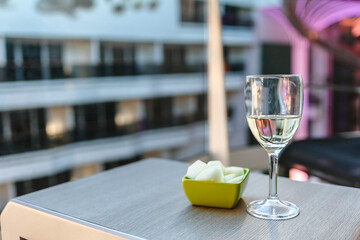Glass of white wine cafe and fruit light snack on table in sunlight. Atmosphere of delightful event and romantic summer. High quality photo