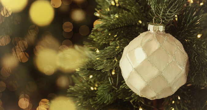 Merry Christmas and Happy Holidays greeting card. Christmas tree with ball and string lights, closeup