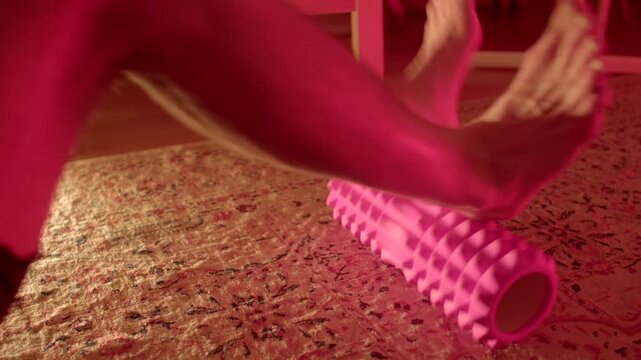Leg massage with foam roller, Gentle calf massage with foam roller under soft pink lighting for relaxation
