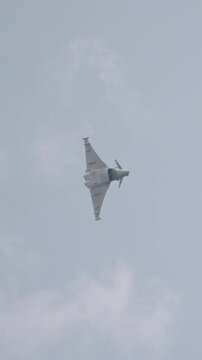 Fast fighter jet during high speed combat maneuvers with clouds