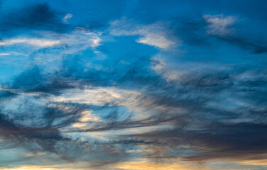 wispy dark clouds in a blue sky