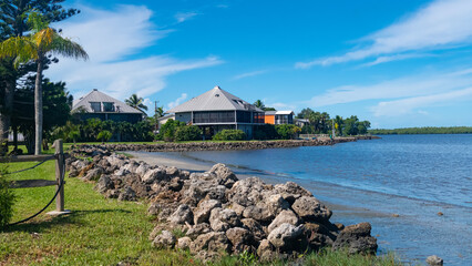 Tropical waterfront homes on sunny Florida coastline with calm ocean view
