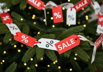 Creative Concept: A Garland Made of Red and White Price Tags Draped on a Christmas Tree