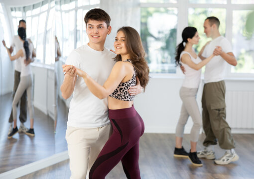 Young people learning tango dance at lessons in dance studio