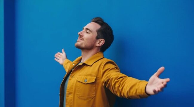 Homem Respirando Profundamente com Jaqueta Jeans Mostarda sobre Fundo Azul