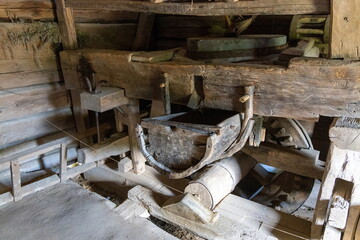 Old wooden grain mill machinery in rustic barn