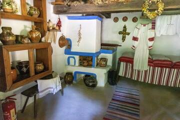 Traditional rural Eastern European house interior with stove and pottery