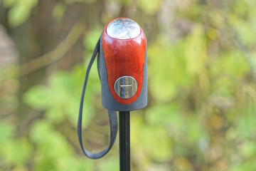 brown black plastic handle on an umbrella with a long cord on a summer street against a green background