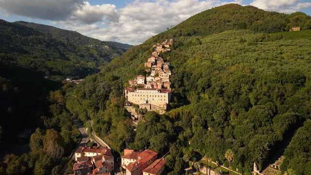 Aerial 4K view of Collodi village and Villa Garzoni garden. Majestic Renaissance architecture and cascading medieval houses on the green hills of Valdinievole, Tuscany, Italy
