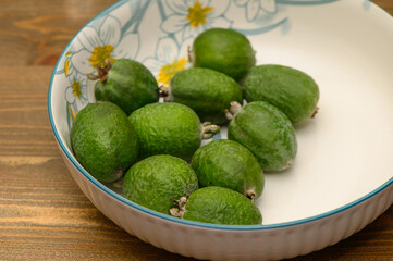 Fresh Feijoas in a White Bowl on Wooden Table