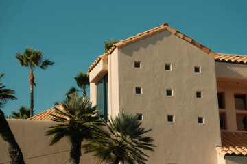 Beautiful southern california san diego house with small windows and red roof and palm trees