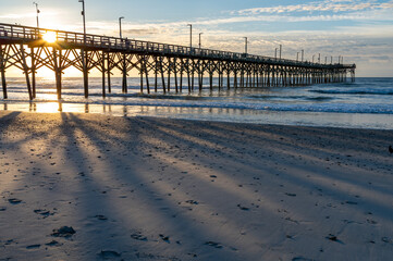 Sunrise Casting Pier Shadows on Beach