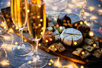 Table served with sparkling wine or champagne and a cheese board ready for Christmas or New Year celebration.	