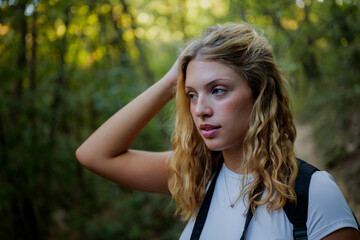 Obraz premium Young woman hiking in forest looking thoughtful