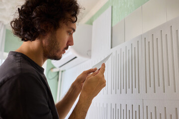 Joyful homeowner redesigns textured wall effortlessly, Homeowner happily personalizes textured wall with self installed decorative mirror tiles for stylish appeal