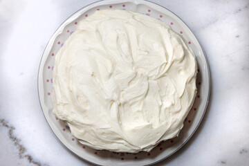Vanilla cake with white buttercream frosting swirled on top and in the middle