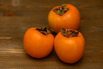 Ripe Persimmon Fruits on Wooden Table