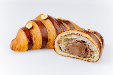 Fototapeta premium Chocolate hazelnut croissant with creamy filling and glossy crust on white background